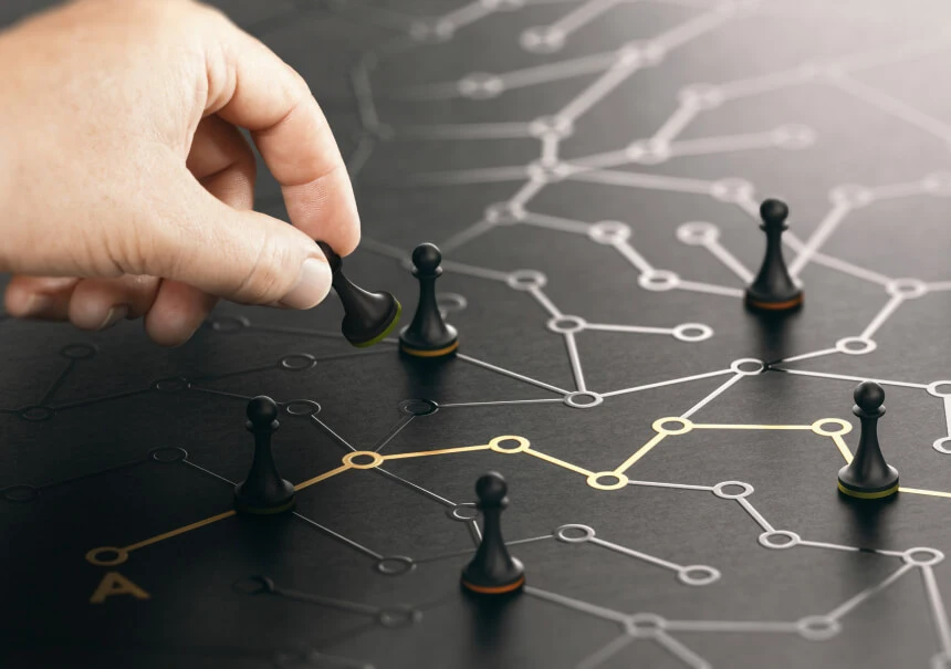 Hand platziert eine Schachfigur auf einem Netzwerk verbundener Knotenpunkte — Illustration einer Omnichannel-Strategie und Kundenkontaktpunkte